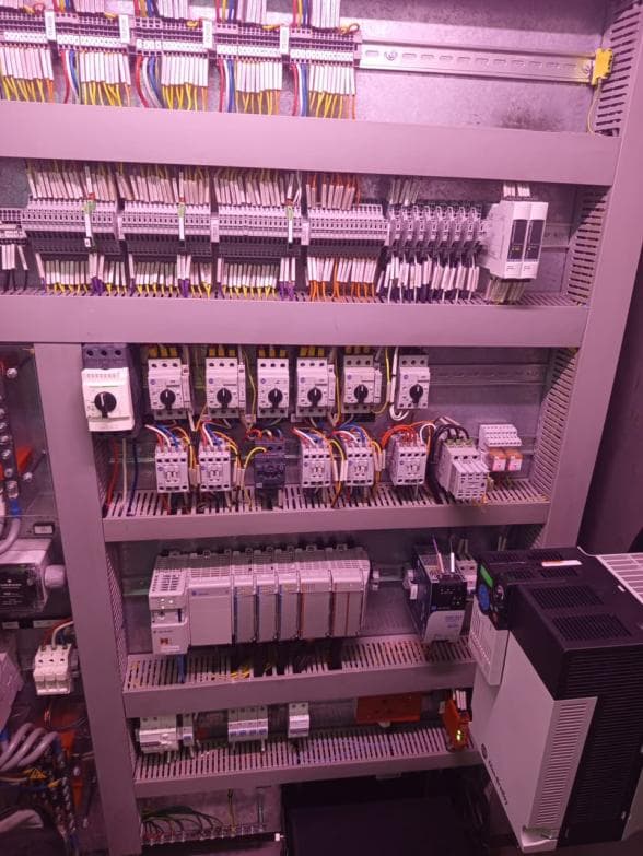 Interior of a re-wired control panel with terminals, contactors and a drive