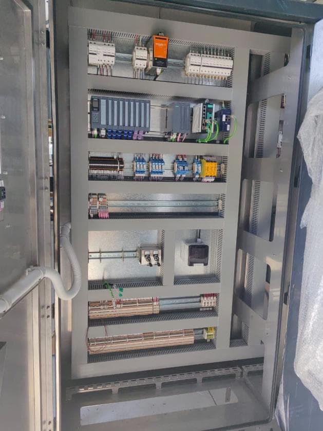 A new stainless steel control panel, doors open, showing the mounted control gear and wiring inside.