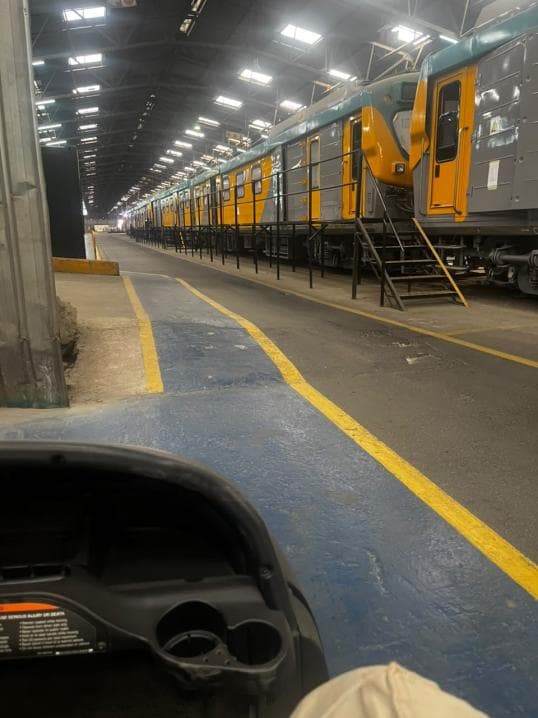 Passenger locomotive carriages lined up along a workshop bay